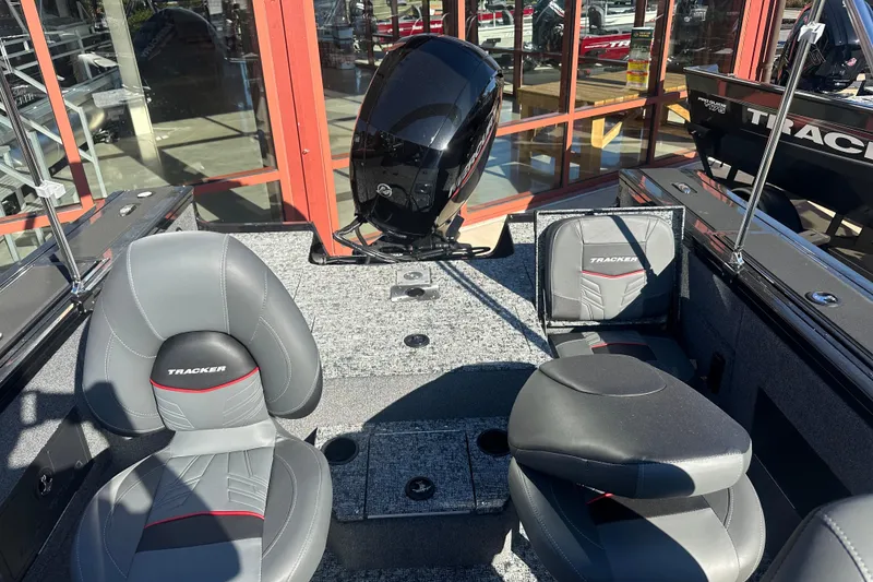 Slide: The Image of 2026 Tracker Targa V-18 Combo boat interior with gray seating and motor, displayed in showroom. - 6