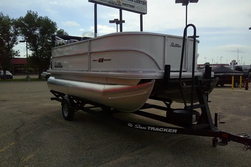 Slide: The Image of 2026 Sun Tracker Party Barge 16 DLX pontoon boat on trailer in parking lot. - 50