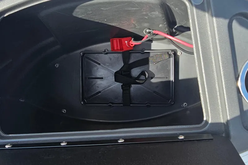 Slide: The Image of Battery compartment of 2026 Sun Tracker Bass Buggy 18 DLX with red cable connection. - 11