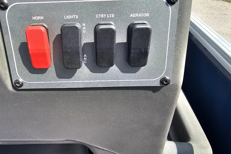 Slide: The Image of Control panel of 2026 Sun Tracker Bass Buggy 18 DLX with switches for horn, lights, and aerator. - 21