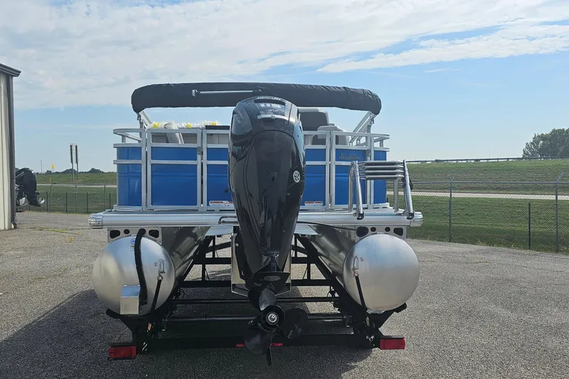 Slide: The Image of 2026 Sun Tracker Fishin' Barge 20 DLX pontoon boat with outboard motor, parked outdoors. - 3