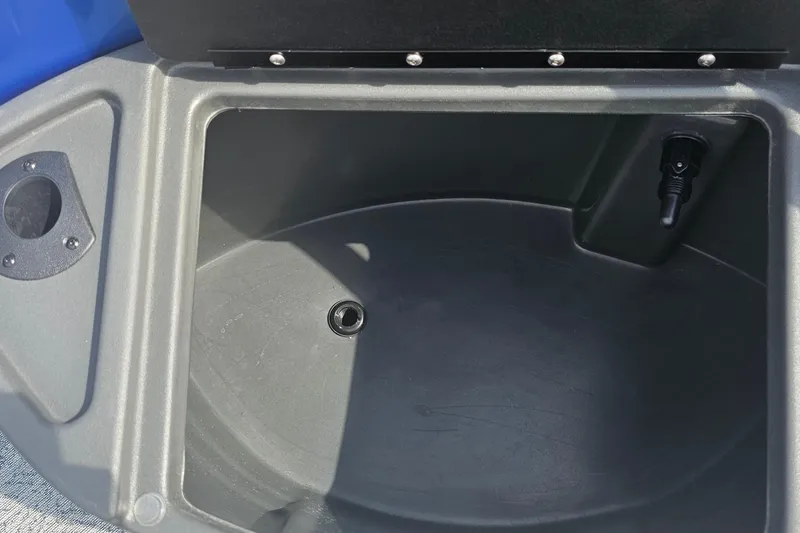 Slide: The Image of 2026 Sun Tracker Fishin' Barge 20 DLX storage compartment with drain and plug. - 9