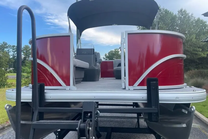 Slide: The Image of 2026 Sun Tracker Party Barge 16 DLX pontoon boat with red exterior and canopy. - 5