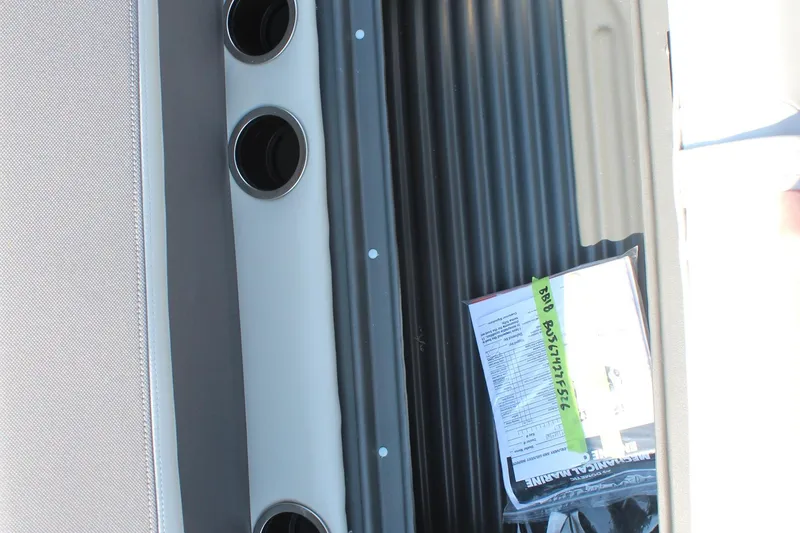 Slide: The Image of 2026 Sun Tracker Bass Buggy 18 DLX interior with cup holders and manual. - 16