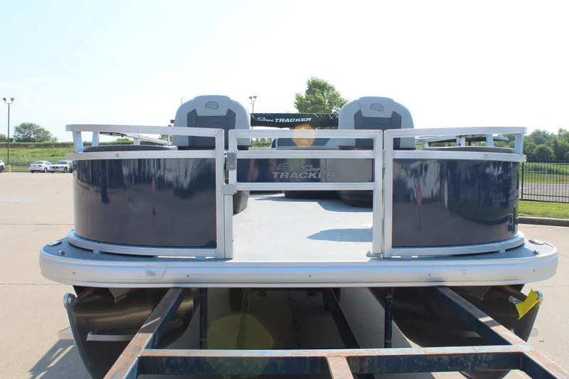 Slide: The Image of 2026 Sun Tracker Bass Buggy 18 DLX pontoon boat on trailer, outdoor setting. - 2