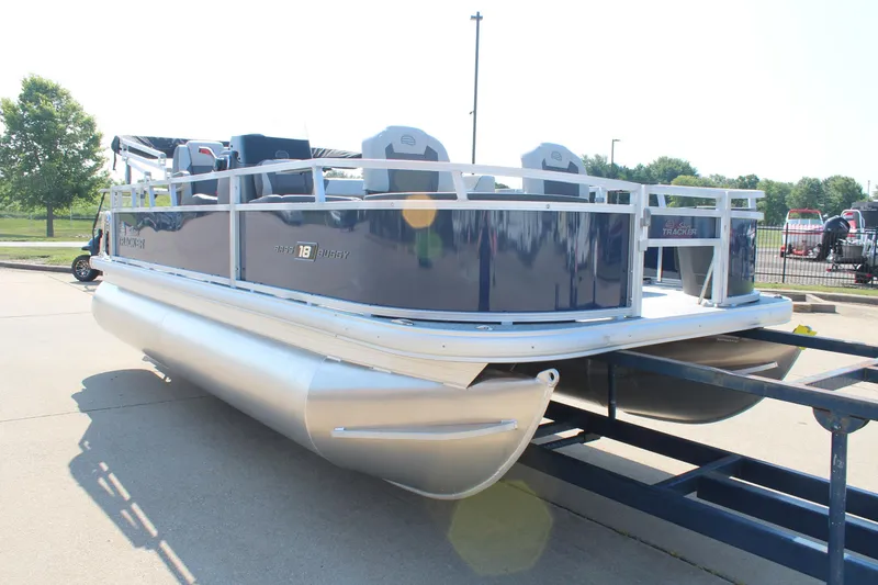 Slide: The Image of 2026 Sun Tracker Bass Buggy 18 DLX pontoon boat on trailer, parked outdoors. - 3