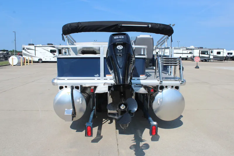Slide: The Image of 2026 Sun Tracker Bass Buggy 18 DLX pontoon boat with outboard motor, parked on concrete. - 6