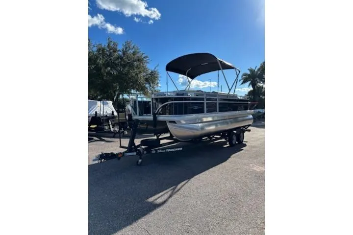 The Image of 2026 Sun Tracker Fishin' Barge 20 DLX pontoon boat on trailer, sunny day. - 0