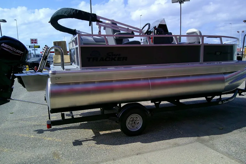 Slide: The Image of 2026 Sun Tracker Bass Buggy 16 XL Select pontoon boat on trailer, parked outdoors. - 3