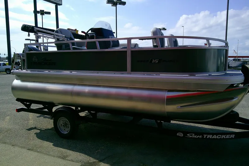 Slide: The Image of 2026 Sun Tracker Bass Buggy 16 XL Select pontoon boat on trailer, side view. - 5