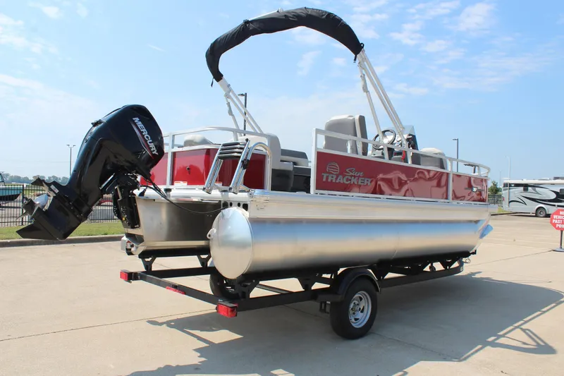 Slide: The Image of 2026 Sun Tracker Bass Buggy 18 DLX pontoon boat with red exterior on a trailer. - 5