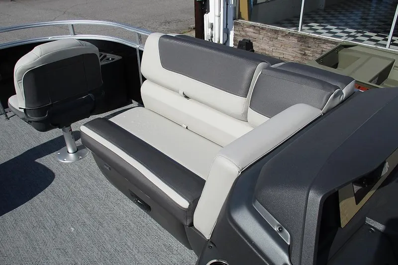 Slide: The Image of 2026 Sun Tracker Fishin' Barge 20 DLX interior seating with gray and white upholstery. - 16