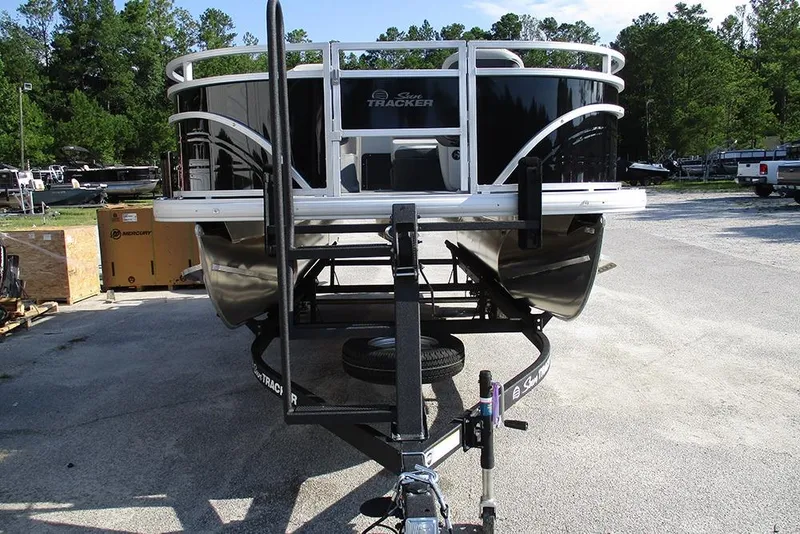 Slide: The Image of 2026 Sun Tracker Fishin' Barge 20 DLX pontoon boat on trailer, parked outdoors. - 4