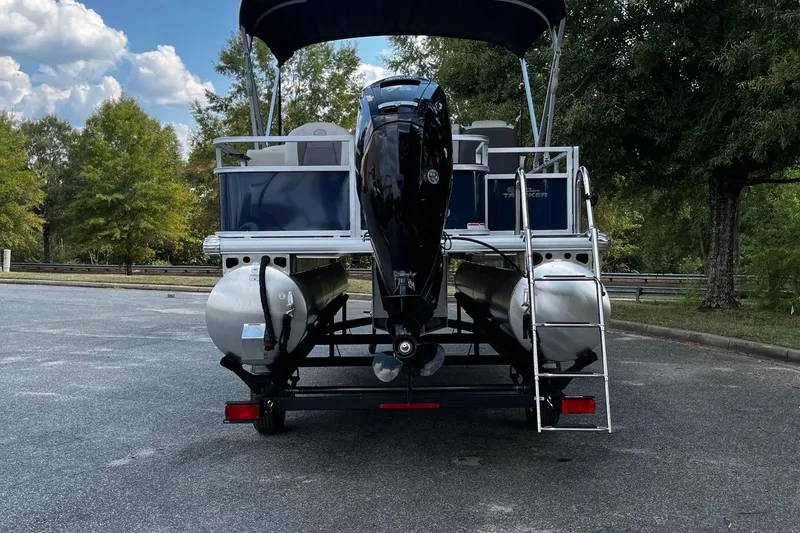 Slide: The Image of 2026 Sun Tracker Bass Buggy 18 DLX pontoon boat, rear view with motor and ladder. - 5