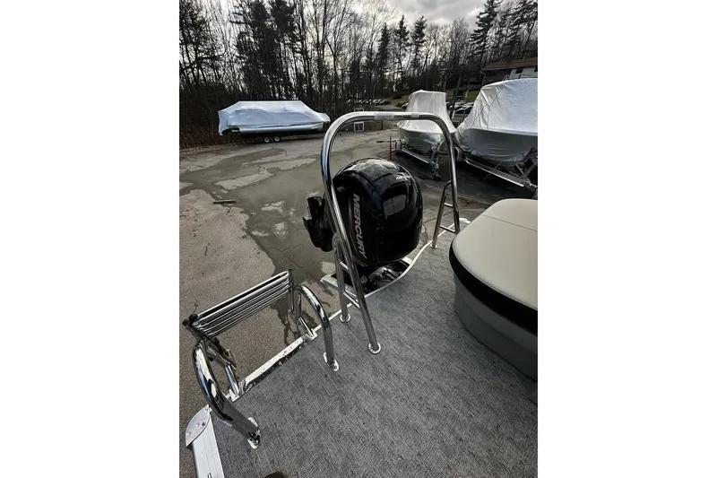 Slide: The Image of 2025 Berkshire 22CL2 LE pontoon boat with outboard motor and seating, parked outdoors. - 7