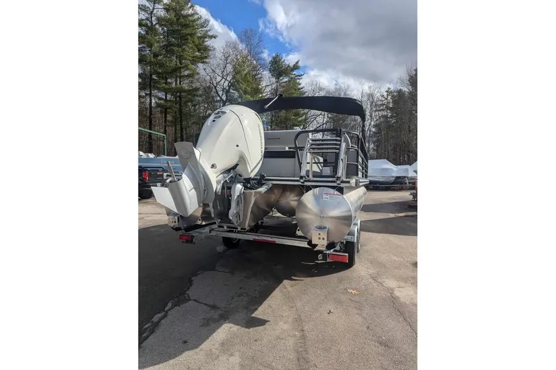 Slide: The Image of 2025 Berkshire 22UL LE pontoon boat with outboard motor, parked outdoors. - 3