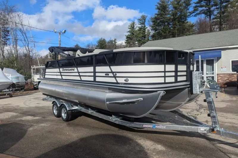 Slide: The Image of 2025 Berkshire 22UL LE pontoon boat on trailer, parked outdoors. - 6