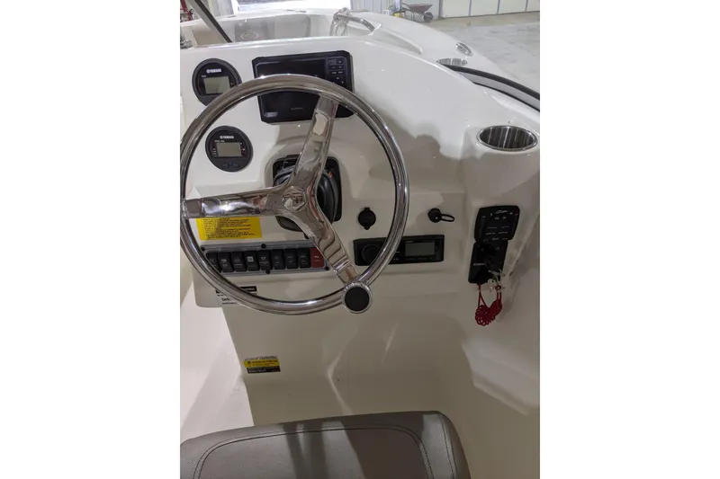 Slide: The Image of 2023 Key West 203 DFS boat dashboard with steering wheel and control panel. - 24