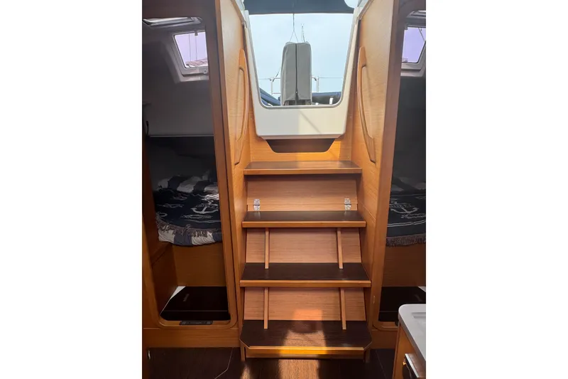 Slide: The Image of Interior of 2023 Dufour 37 yacht, featuring wooden steps and cozy cabin spaces. - 10