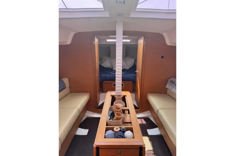 Slide: The Image of Interior of 2023 Dufour 37 yacht, featuring cozy seating and elegant wooden finishes. - 12