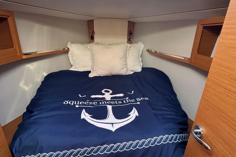 Slide: The Image of Cozy cabin interior of 2023 Dufour 37 yacht with nautical-themed bedding. - 17