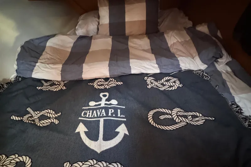 Slide: The Image of Cozy bed with nautical-themed blanket on a 2023 Dufour 37 yacht. - 19