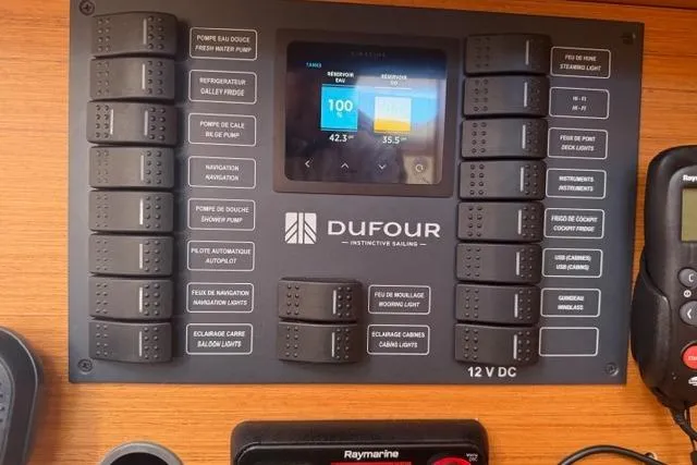 Slide: The Image of Control panel of a 2023 Dufour 37 sailboat with various switches and display. - 22