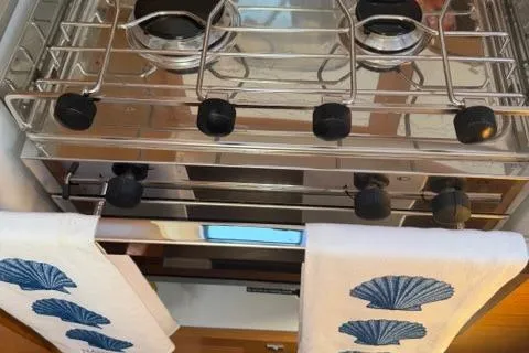 Slide: The Image of 2023 Dufour 37 yacht kitchen with stove and decorative towels. - 23