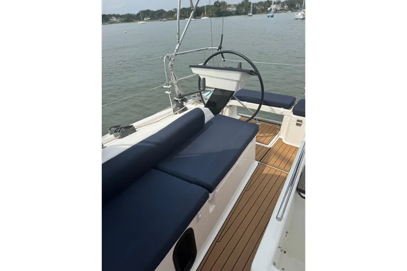 Slide: The Image of 2023 Dufour 37 sailboat cockpit with blue cushions and wooden deck. - 5