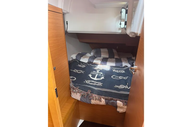 Slide: The Image of Cozy cabin interior of 2023 Dufour 37 yacht with nautical-themed bedding. - 8