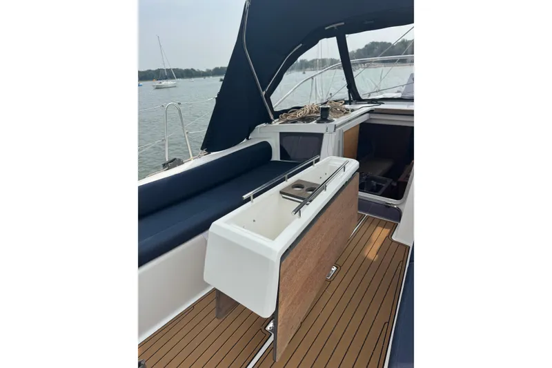 Slide: The Image of 2023 Dufour 37 yacht cockpit with teak flooring and seating, docked by the water. - 9