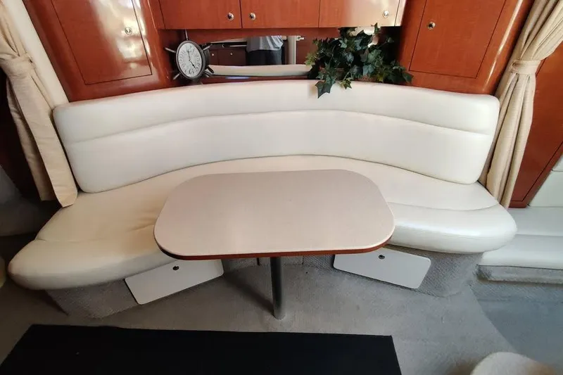 Slide: The Image of Interior of 2002 Sea Ray 320 Sundancer with curved seating and table. - 20