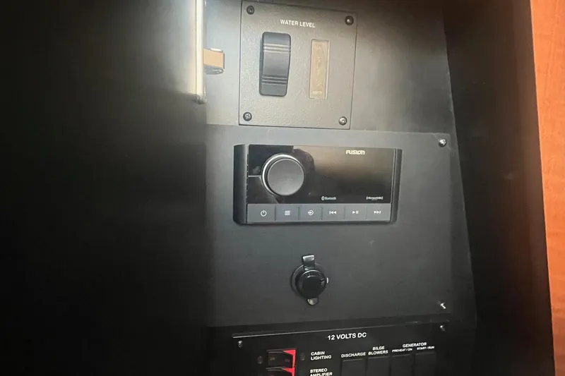 Slide: The Image of Control panel of a 2002 Sea Ray 320 Sundancer boat, featuring water level gauge and audio system. - 23