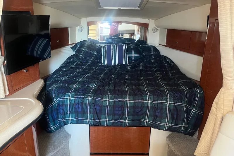 Slide: The Image of 2002 Sea Ray 320 Sundancer cabin with bed, TV, and wood cabinetry. - 24