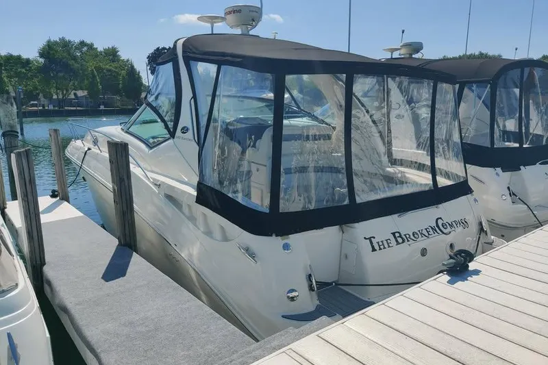 Slide: The Image of 2002 Sea Ray 320 Sundancer docked, featuring clear canopy and sleek design. - 4