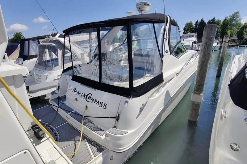 Slide: The Image of 2002 Sea Ray 320 Sundancer docked, featuring "The Broken Compass" name on the stern. - 5