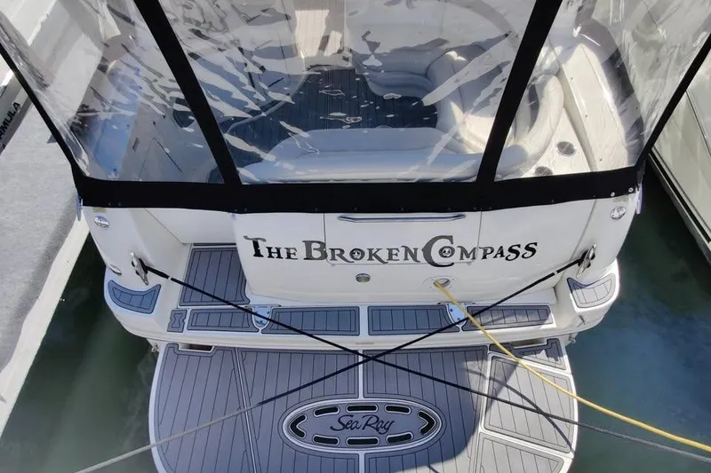 Slide: The Image of 2002 Sea Ray 320 Sundancer boat named "The Broken Compass" docked with clear canopy. - 7