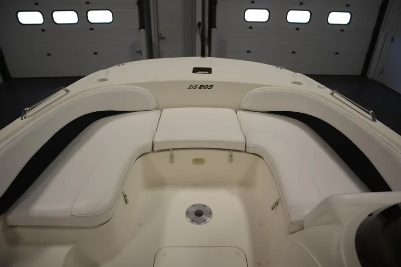 Slide: The Image of 2007 Glastron 205 DS boat interior with white seating and storage compartments. - 12