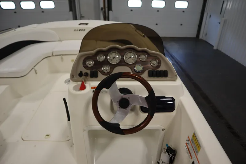 Slide: The Image of 2007 Glastron 205 DS boat dashboard with steering wheel and gauges in a garage setting. - 20
