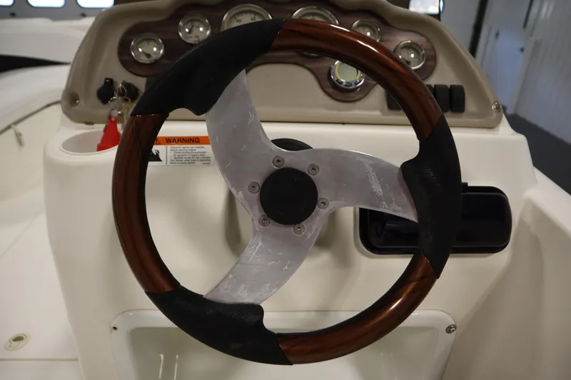 Slide: The Image of Steering wheel and dashboard of 2007 Glastron 205 DS boat, featuring gauges and controls. - 21