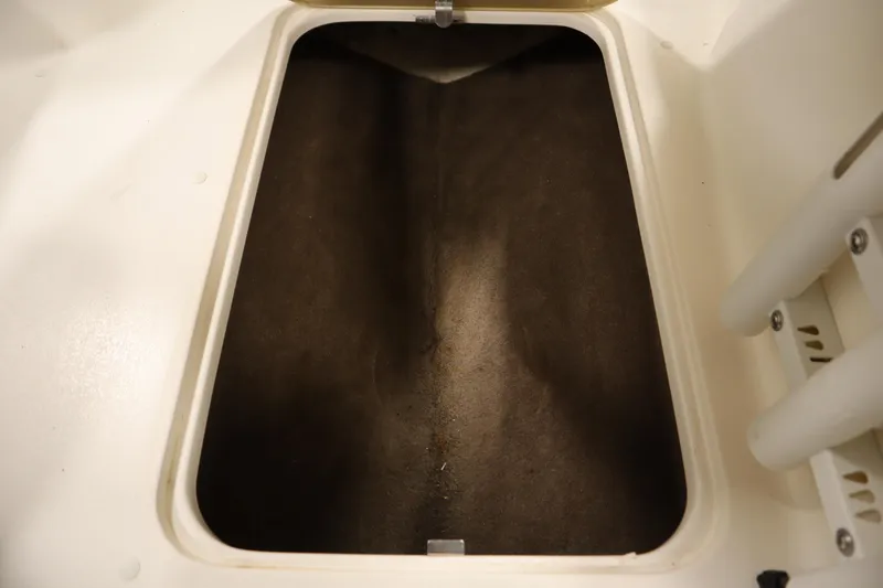 Slide: The Image of Storage compartment of a 2007 Glastron 205 DS boat, featuring a dark interior. - 32