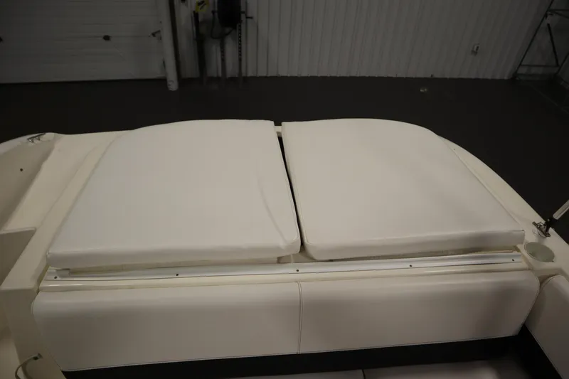 Slide: The Image of 2007 Glastron 205 DS boat with white cushioned seating in a garage setting. - 36
