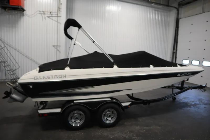 Slide: The Image of 2007 Glastron 205 DS boat with cover on trailer in indoor storage. - 44