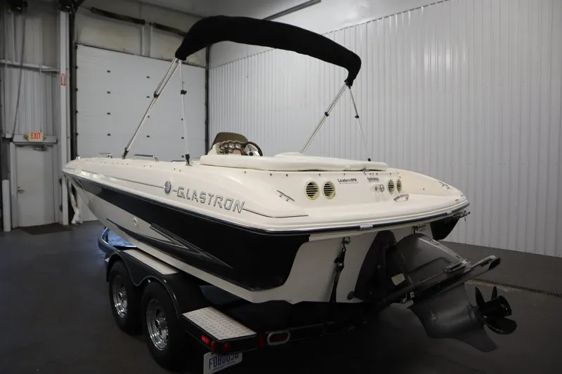 Slide: The Image of 2007 Glastron 205 DS boat in indoor storage, featuring a sleek design and dual-axle trailer. - 7