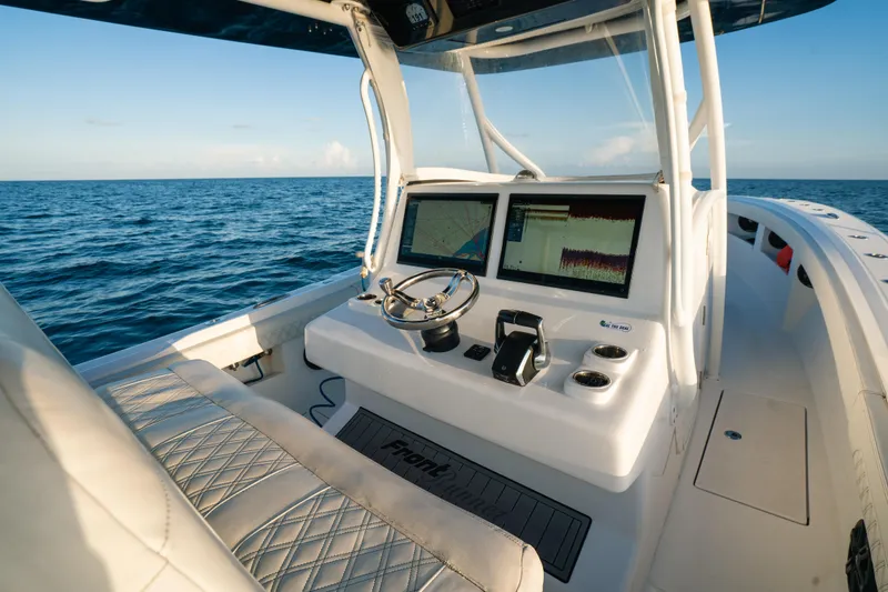 Slide: The Image of 2023 Front Runner 36 Center Console boat interior with navigation screens, steering wheel, and ocean view. - 14