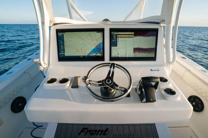 Slide: The Image of 2023 Front Runner 36 Center Console helm with dual navigation screens on open water. - 15
