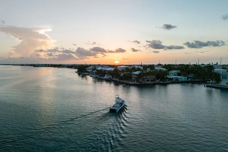 Slide: The Image of 2023 Front Runner 36 Center Console boat cruising at sunset on a serene waterway. - 27