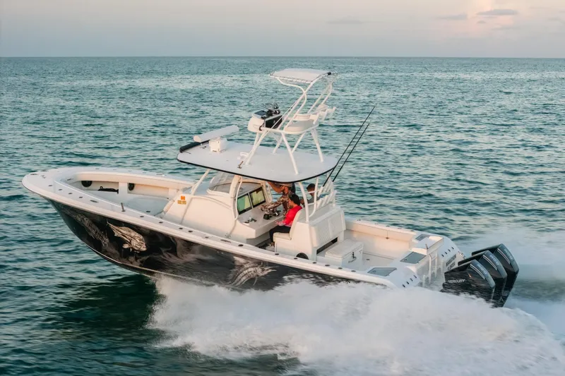 Slide: The Image of 2023 Front Runner 36 Center Console boat cruising on open water at sunset. - 7