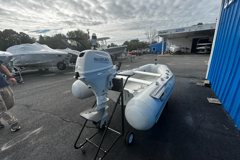 Slide: The Image of 2019 Brig Falcon 300 inflatable boat with Suzuki outboard motor in a boatyard setting. - 6