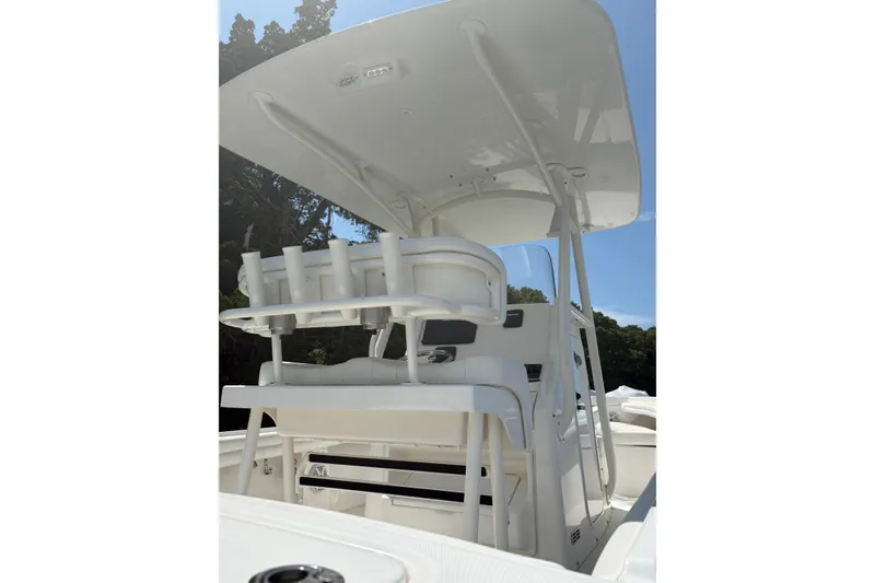 Slide: The Image of 2017 Regulator 23 Forward Seating boat with T-top and rod holders, viewed from the rear. - 12